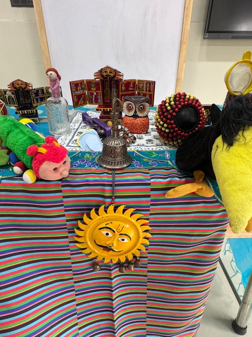 Storytelling props display with Kavads, plush characters, and folk instruments