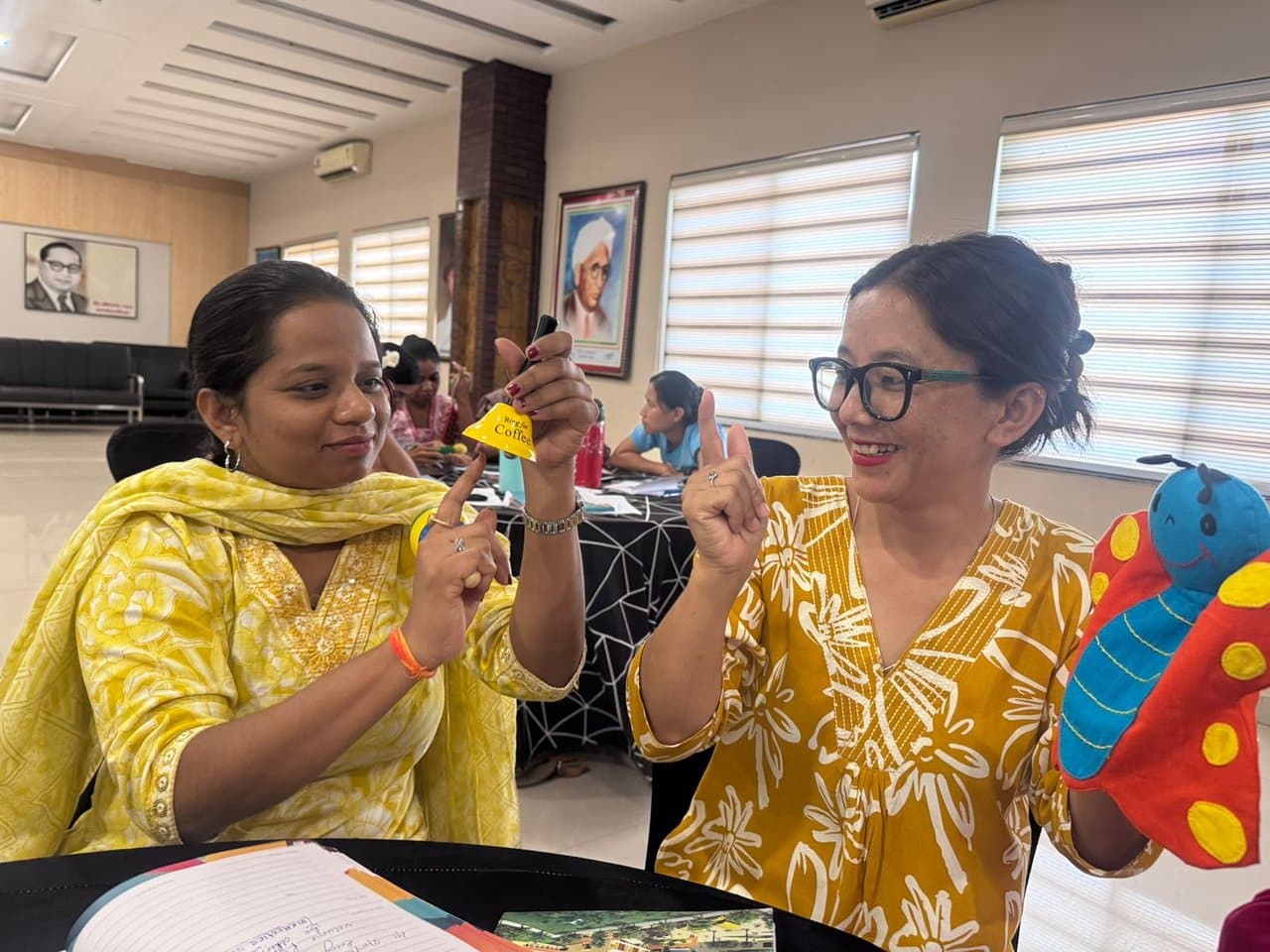 Educators with a handbell and butterfly puppet during an interactive workshop