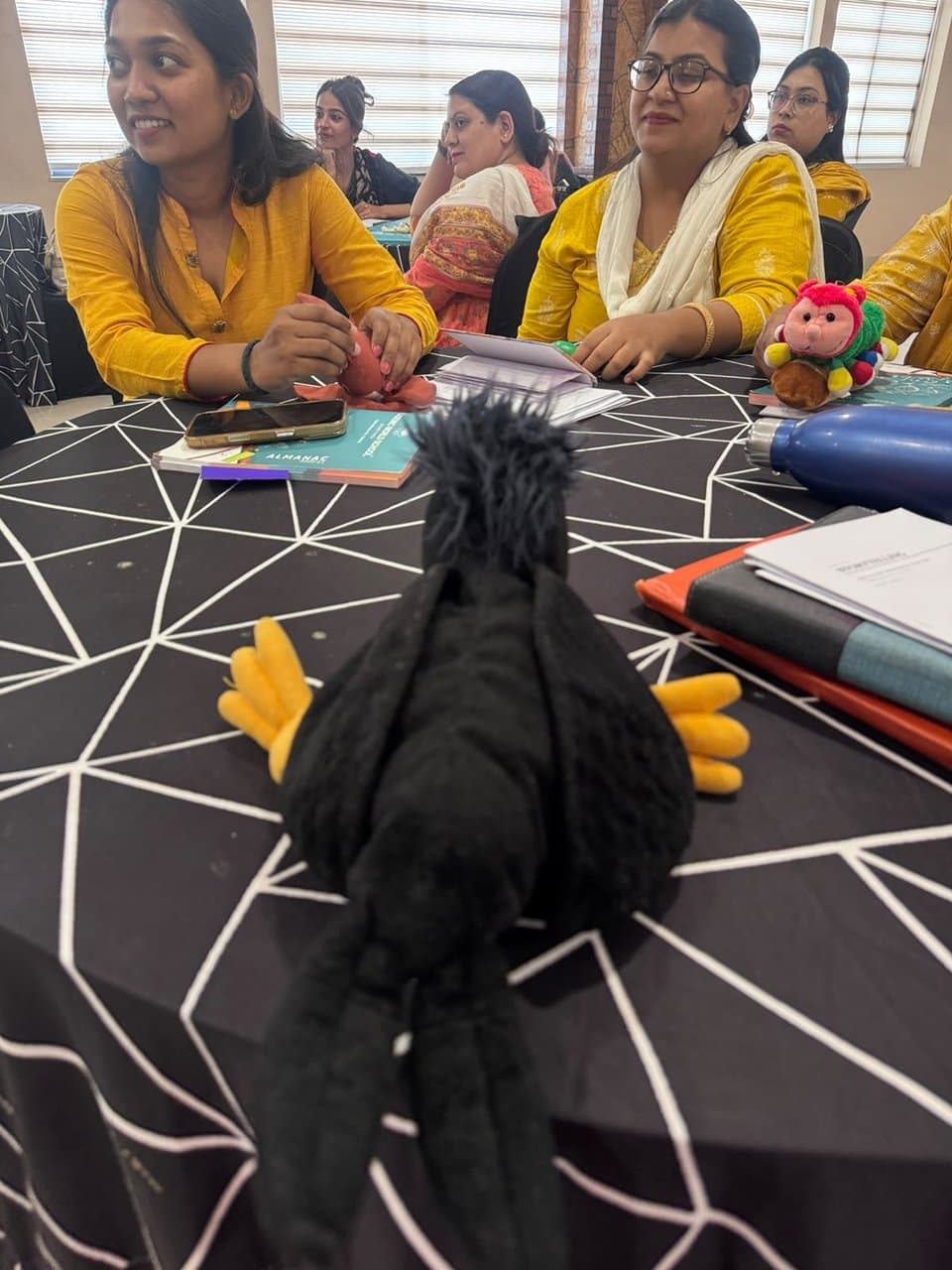 Educator workshop table with crow puppet and storytelling materials