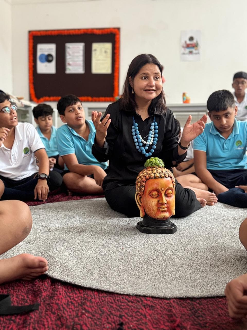 Floor storytelling session with Buddha prop and school boys