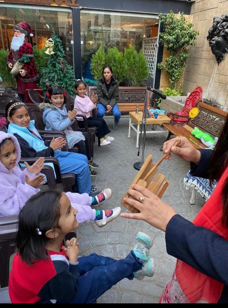 Outdoor storytelling with wooden percussion instrument and children